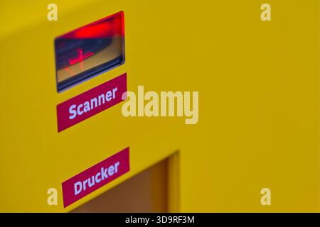 At a DHL Packstation, red laser scanners and printers for shipping labels are installed to scan parcels or to provide them with shipping labels and to Stock Photo