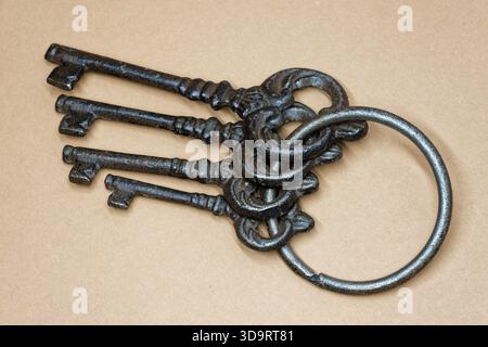 Group of four vintage metal keys lying on a plain surface. Concept for access security opportunity leadership and unlocking new beginnings in business Stock Photo