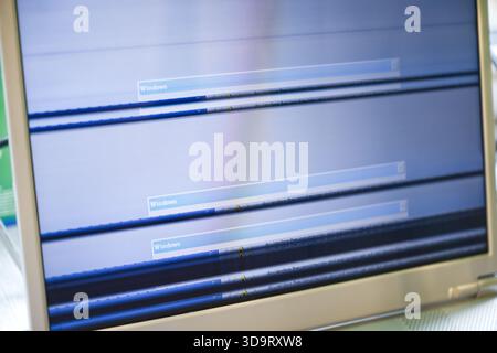A close-up of a computer monitor displaying a distorted screen with horizontal lines and error messages. The monitor appears to be malfunctioning, sho Stock Photo