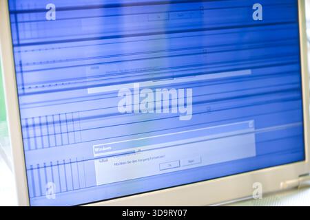 A close-up of a computer screen displaying a distorted blue interface with horizontal lines and a dialog box. The screen shows signs of malfunction or Stock Photo