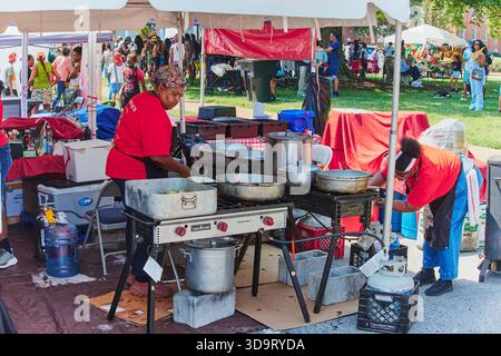 Two women cook food for attendees at the 2025 Delaware Caribbean Festival in Dover, Delaware, preparing fresh dishes amid the lively cultural celebrat Stock Photo