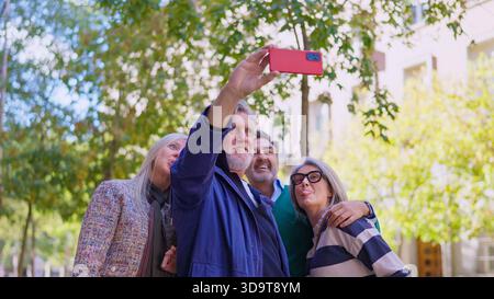 Group of cheerful seniors taking a selfie with a smartphone Stock Photo
