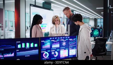 Analyzing Data On Multiple Screens: Diverse Business Meeting In Office Stock Photo
