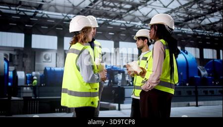 Workers Enjoying Coffee Break At Power Plant Industrial Facility. Woman Engineer Conducting Training Stock Photo