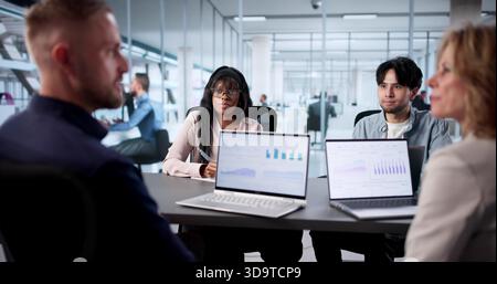 Predictive Business Meeting: Diverse Analysts Collaborate On Financial Dashboard Stock Photo