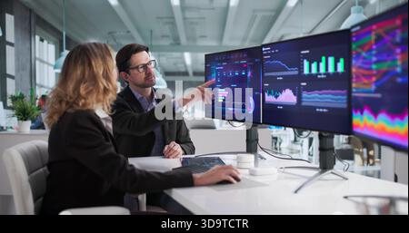 Financial Analysts Analyzing Data On Computer Dashboard For Business Performance. Stock Photo