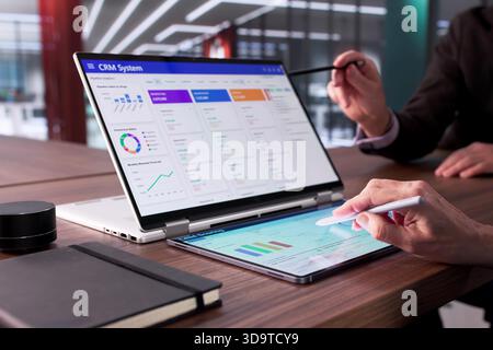 Man Using CRM Software On Laptop To Support Global Sales. Stock Photo