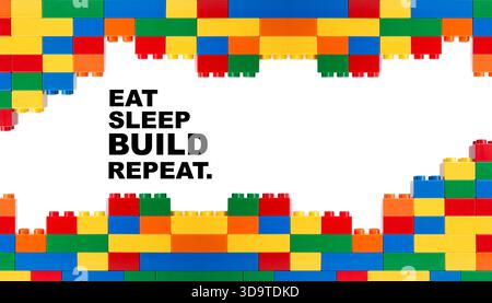 Colorful building blocks framing motivational text about eating, sleeping, building, and repeating on a white background Stock Photo