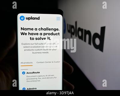 Stuttgart, Germany - 11-26-2025: Person holding smartphone with web page of US company Upland Software Inc. on screen in front of logo. Stock Photo
