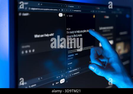 Hand pointing at Google Gemini and ChatGPT AI interfaces on split screen monitor with blue light. High quality photo Stock Photo