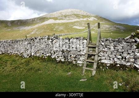 'Smearsett Scar' and Wooden Ladder Stile over Dry Sone Wall on the Stainforth to Feizor Bridleway in Ribblesdale in the Yorkshire Dales, England, UK Stock Photo