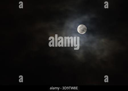 full moon covering by cloud floating on sky in night background Stock Photo