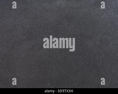 Subtle interplay of black and gray granules on a textured paper surface Stock Photo