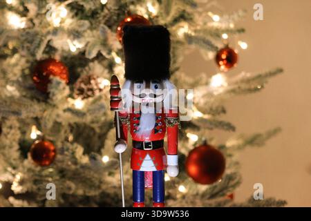 Wooden nutcracker figurine photographed in front of a decorated Christmas tree during a holiday display in Novi Sad on December 6, 2025. Stock Photo