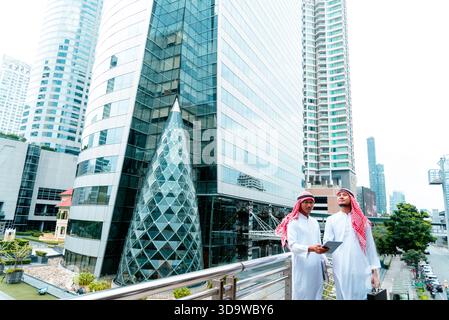 Arab team hold digital tablet uae union teamwork people. Digital marketing arab group of people using smart tablet discuss modern muslim UAE city. Ent Stock Photo