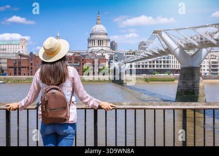 Rear view of a happy tourist woman with hat looking at the famous landmarks of London, England, as a city travel concept Stock Photo