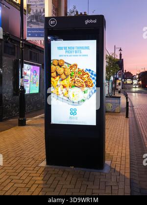 BT Global Street Hub on Winchester Street advertising the Co-Op supermarket, Basingstoke, UK. Street Hubs offer free public digital communication Stock Photo