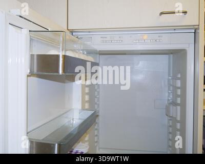 Clean empty refrigerator with open door and transparent shelves, perfect for household appliance commercial or modern kitchen interior promo Stock Photo