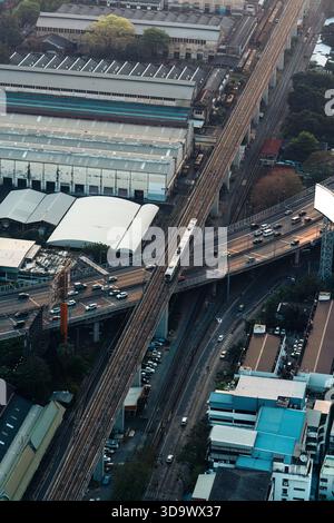 Aerial view of Skytrain running through building and car on expressway in downtown at Bangkok, Thailand Stock Photo