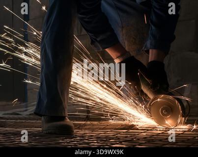Work of electric saw for metal shot in studio being repaired sparks all around worker Stock Photo