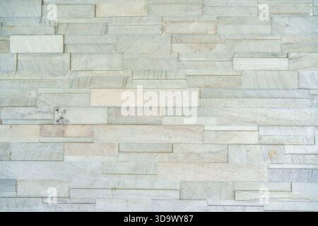 Layered rectangular stacked stone wall with gray color rough natural surface texture background Stock Photo