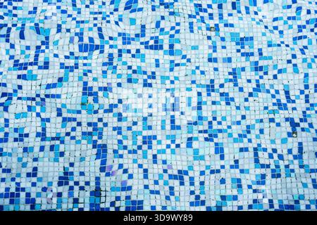 Detail of swimming pool surface with ceramic mosaic tiles in blue and white, water ripple effect pattern background Stock Photo