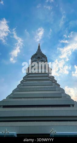 Massive White Tiered Pagoda Architecture of Wat Paknam Phasi Charoen Temple Under a Partly Cloudy Sky Stock Photo