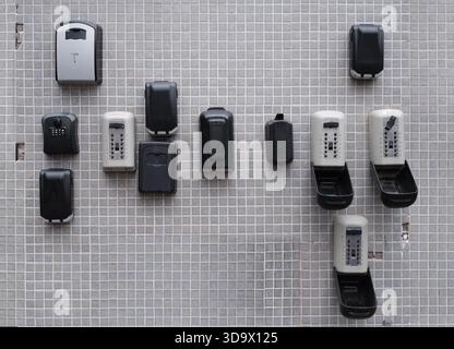 Multiple Key Lock Boxes Mounted On Outdoor Tiled Wall Used For Secure Storage And Access Control In Real Estate And Property Management Stock Photo