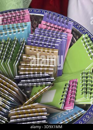 Vibrant collection of colorful spiral notebooks neatly arranged decorative blue tray. Small notepads, featuring various bright hues, offer cheerful an Stock Photo
