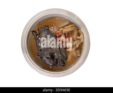 Widely celebrated in Chinese and Asian culinary traditions, this nourishing stew is known as "Black Chicken Soup" or "Silkie chicken soup" isolated on Stock Photo