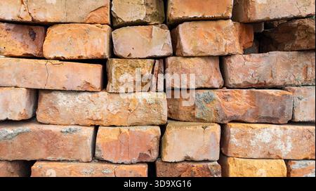 Red old brick wall background, brick wall texture. Bricks stack stacked on top of each other. Building material. Old broken brick, close-up. Construct Stock Photo