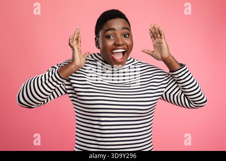 Joyful Woman With Short Hair Expressing Excitement Against a Bright Pink Background During a Playful Moment Stock Photo