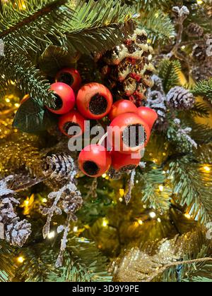 Seasonal Christmas tree decorations with red yew berries prominent. Ornaments include pine cones, real fir cones on frosted twigs. Stock Photo