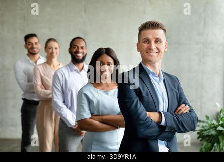 Diverse Team of Business Professionals Posing Together in Modern Office Setting Stock Photo