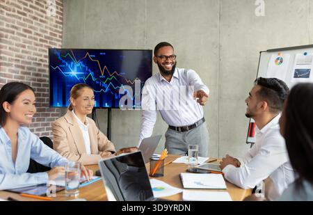 Multiracial Business Team Collaborating on Innovative Ideas in Modern Office Setting Stock Photo