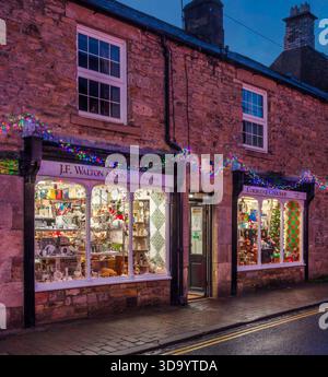 A view at dusk at Christmas of decorated & illuminated shop fronts in Corbridge village, Northumberland Stock Photo