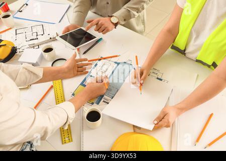 Team of constructors working at table in room, closeup Stock Photo
