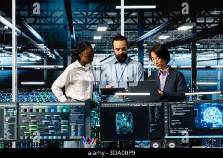 Team of data center coworkers in office running AI forecasting simulations, tracking performance. Teamworking server hub colleagues using PC to integrate deep learning APIs into software platforms Stock Photo
