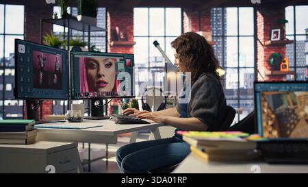Woman expert developer works with photo editing software in the creative workspace, digital media. Using dual monitors to ensure productivity and innovation in the graphic design world. Camera A. Stock Photo