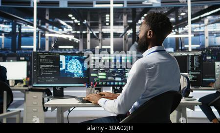 Data center programmer uses machine learning node tree program to identify equipment issues. Server hub worker reviewing artificial intelligence data analysis graph to minimize failures, camera A Stock Photo