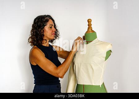 Female fashion designer draping fabric on a dress form Stock Photo
