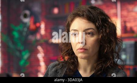 Software expert at workstation programming on pc and writing lines of code, using coding tools and a terminal window interface. Woman debugging software for web development. Camera B. Stock Photo