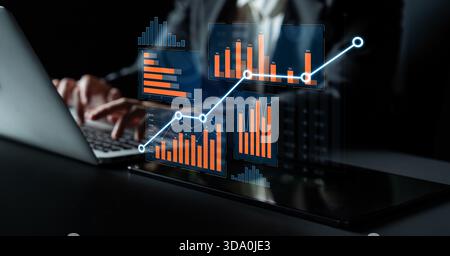 A business professional works with a laptop displaying vibrant digital graphs and charts, visualizing data trends and insights in a sleek modern Stock Photo