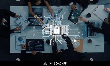 A business team collaborates on data security strategy with laptop displays, charts, and digital lock symbols, emphasizing innovation and protection Stock Photo