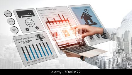 A person interacts with a futuristic technology interface showcasing smart home data and energy analytics on a laptop amid an urban landscape. Gantry Stock Photo