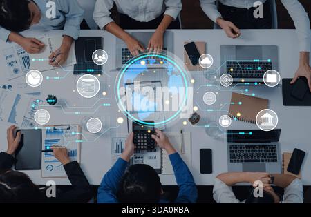 A diverse group of professionals collaborates using digital tools in a modern workspace. They analyze data and discuss strategies while surrounded by Stock Photo