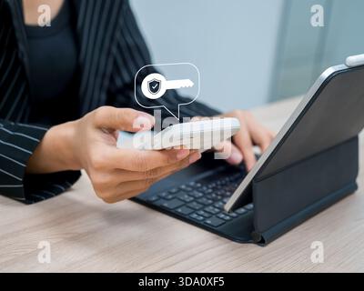 Businesswoman using two-factor authentication or 2FA via smartphone and tablet to secure online access. Data protection, identity verification, login Stock Photo