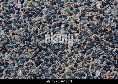 Small blue stones in exposed aggregate concrete close-up abstract textured background Stock Photo