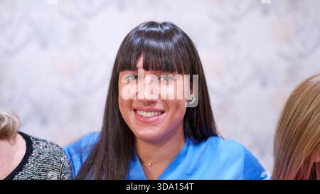 Young nurse smiling working in a nursing home setting Stock Photo