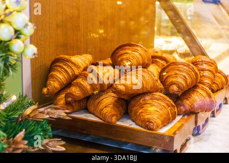 Fresh butter croissants stacked on bakery display. Stock Photo